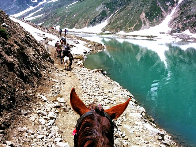 passeggiata a cavallo su lago in montagna con neve